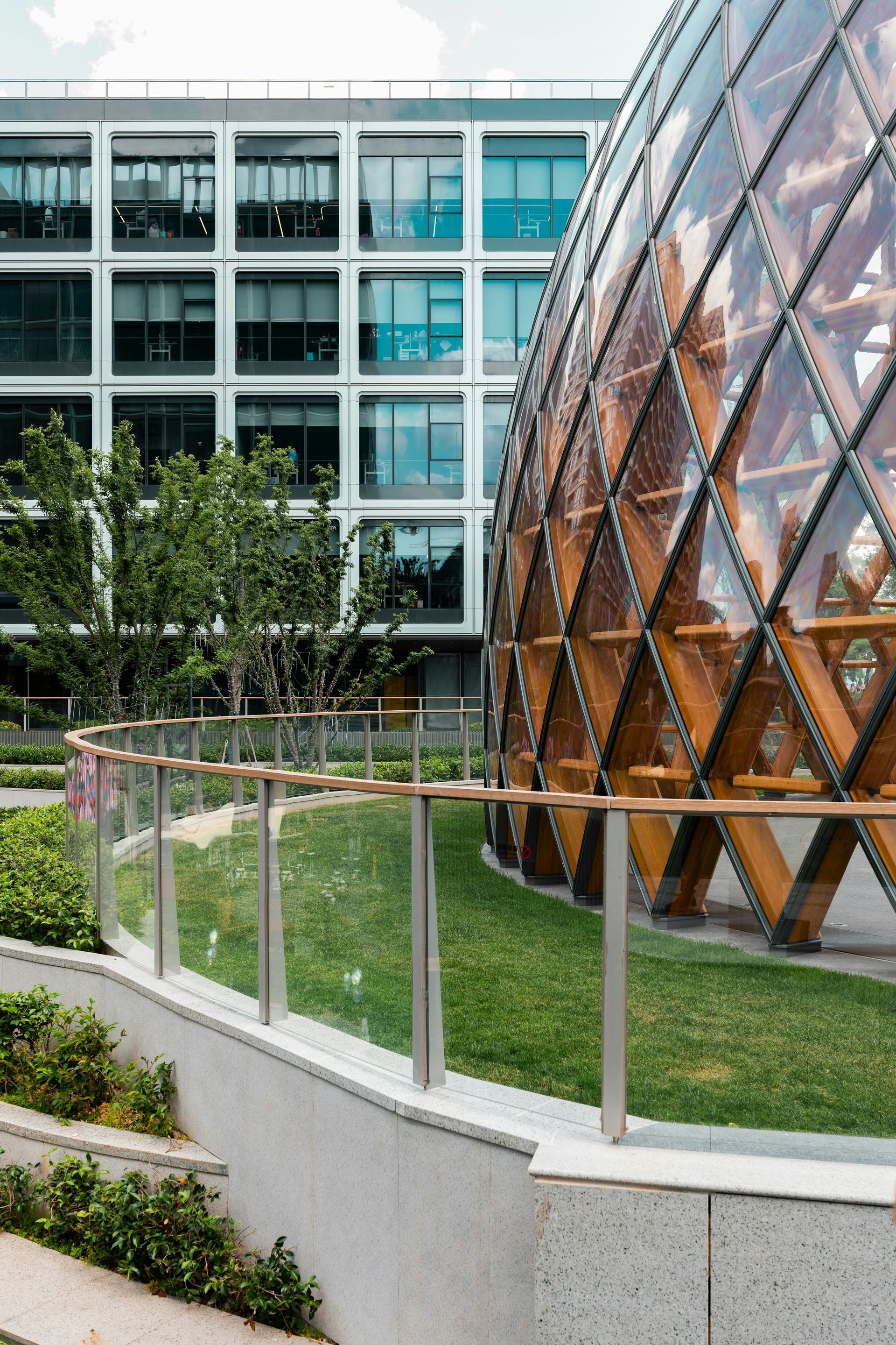 Modern building with glass dome and green landscaping